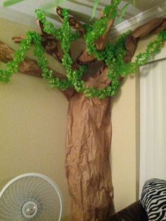 a tree made out of brown paper sitting on top of a table next to a fan