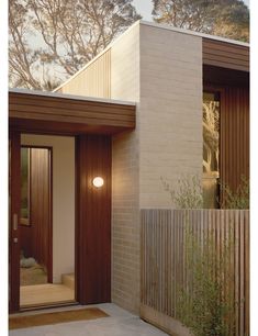 a modern house with wooden doors and brick walls