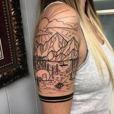 a woman with a mountain scene tattoo on her arm