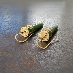 These Jade Torpedo Earrings feature an eye-catching design crafted from 18k gold and authentic jade. The verdant gem is uniquely Captured in 18k gold to create an elegant and dynamic look, perfect for any occasion. 18k gold, jade. 2 1/8 inch length. Made to order and will ship in 3-4 weeks. Yellow Gold Jade Earrings, Luxury Green Jade Earrings, Modern Yellow Gold Jade Jewelry, Modern Green Earrings With Polished Finish, Modern Green 14k Gold Earrings, Jade Stone, Hook Earrings, Design Crafts, The Beauty