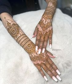 two hands with henna tattoos on them