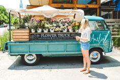 a woman standing in front of a flower truck