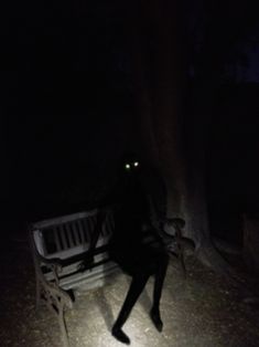 a person sitting on a bench in the dark