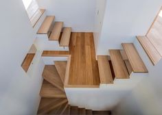 an overhead view of some wooden stairs in a house with white walls and wood flooring