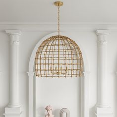 a living room with white walls and gold chandelier hanging from the ceiling above it