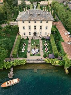 an aerial view of a house and its surrounding gardens with a boat in the water