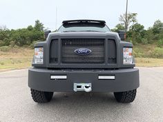 the front end of a gray truck parked in a parking lot