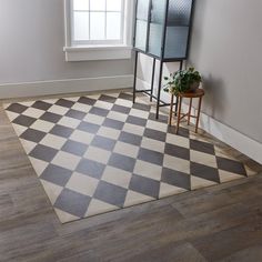 a checkered area rug in the corner of a room