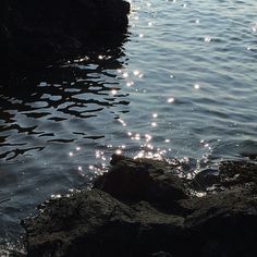 the sun shines brightly on the water and rocks