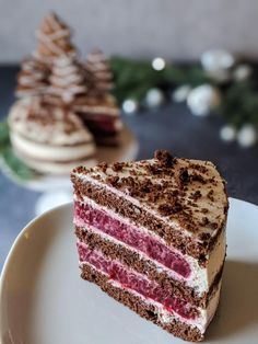 a piece of cake sitting on top of a white plate next to a christmas tree