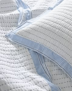 an unmade bed with blue and white striped sheets on top of it's edges