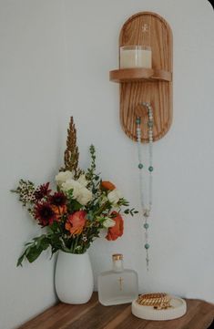 a vase with flowers sitting on a table next to a candle and some other items