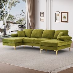 a living room with a large green sectional couch and white rugs on the floor