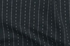 a black and white striped fabric with small dots on the side, as well as lines