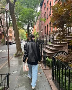 a person walking down the sidewalk with an umbrella