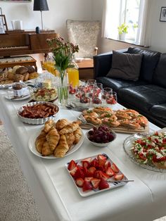 a table filled with food and drinks on top of a white tablecloth covered table