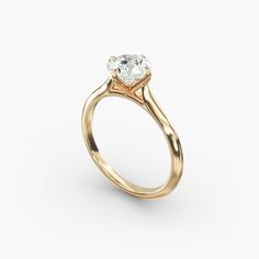 a yellow gold engagement ring with an oval cut diamond in the center, on a white background