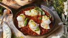 an iron skillet filled with baked eggs and tomato sauce