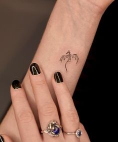 a woman's hand with some tattoos on it