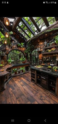 an outdoor kitchen with wood floors and green plants on the ceiling, surrounded by greenery