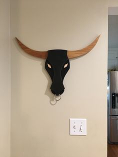 a cow's head mounted to the side of a wall with a light switch