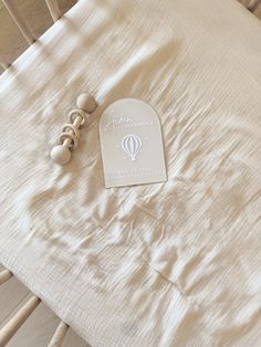 a baby crib with a white sheet and wooden toys