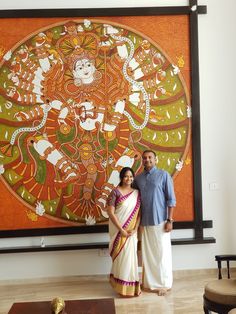 a man and woman standing in front of a painting