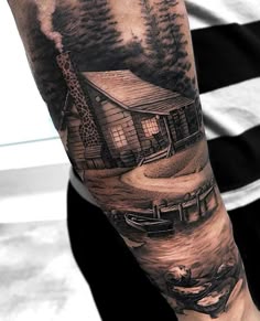 a man's arm with a house and trees on it