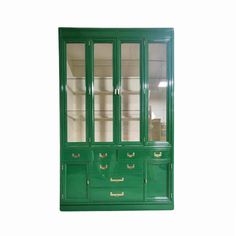 a green china cabinet with glass doors and drawers on the bottom, in front of a white background