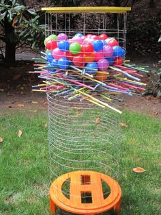 an outdoor play area with plastic balls and sticks in the cage on top of it