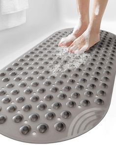 a person standing on top of a bath mat with lots of bubbles and water all over it