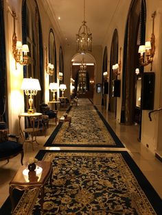 the hallway is lined with antique furniture and chandeliers, as well as lamps