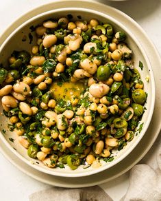 a white bowl filled with beans and greens