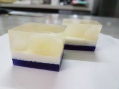 two pieces of soap sitting on top of a white table next to another piece of food