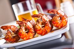 shrimp skewers on a white plate with the words russian in large letters above them