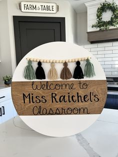 a sign that says welcome to miss ratchel's classroom with tassels hanging from it