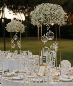 the tables are set up with white linens and gold place settings for an elegant wedding