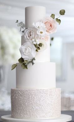 a white wedding cake with flowers on top