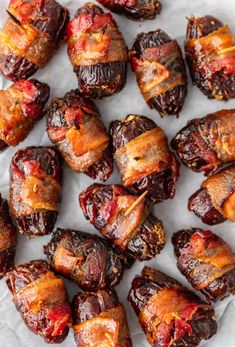 bacon wrapped dates on a white plate