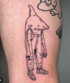 a man's leg with a cartoon character drawn on it and a bird flying over his head