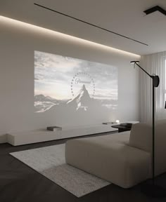 a living room with a large screen on the wall next to a couch and lamp