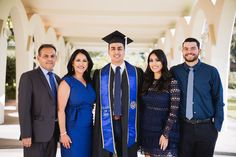 a group of people standing next to each other wearing graduation caps and gowns in front of an archway