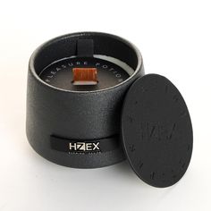 a small black candle with a wooden lid