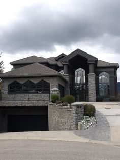 a large house with a car parked in front of it and two garages on the other side