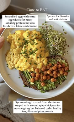 a person holding up a plate with eggs and vegetables on it, along with other food items