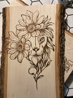 a piece of wood that has been carved with flowers and a lion's face on it