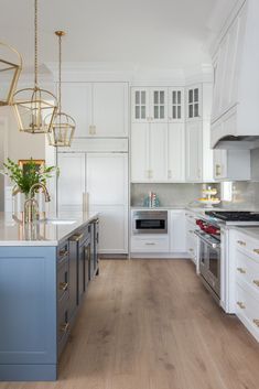 light wood flooring and white cabinets with blue island gold hanging pendants White Kitchen Wood Floors, Bedroom Transitional, Coastal Kitchen Design, Wood Floor Kitchen, Classic Kitchen, White Kitchen Design, Coastal Kitchen