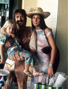 a man, woman and child standing in front of a store