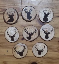 six coasters with deer heads on them sitting on top of a wooden table next to each other