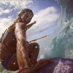 a woman riding a surfboard on top of a wave